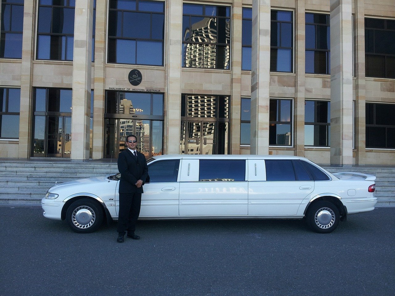 A chauffeur by a limousine, ready to provide limo services